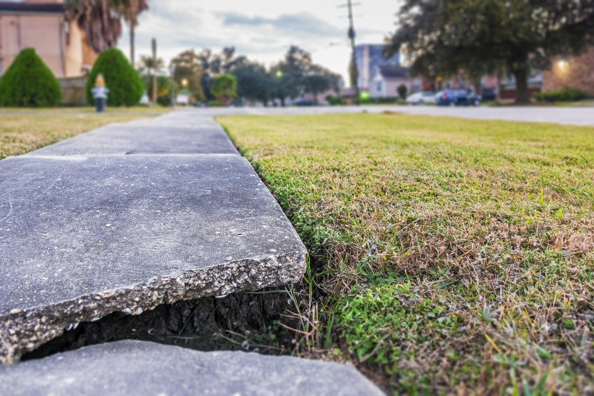 Cracked concrete sidewalk needing repair in Fort Worth – professional patching and leveling services by Fort Worth Brick Repair masonry contractors