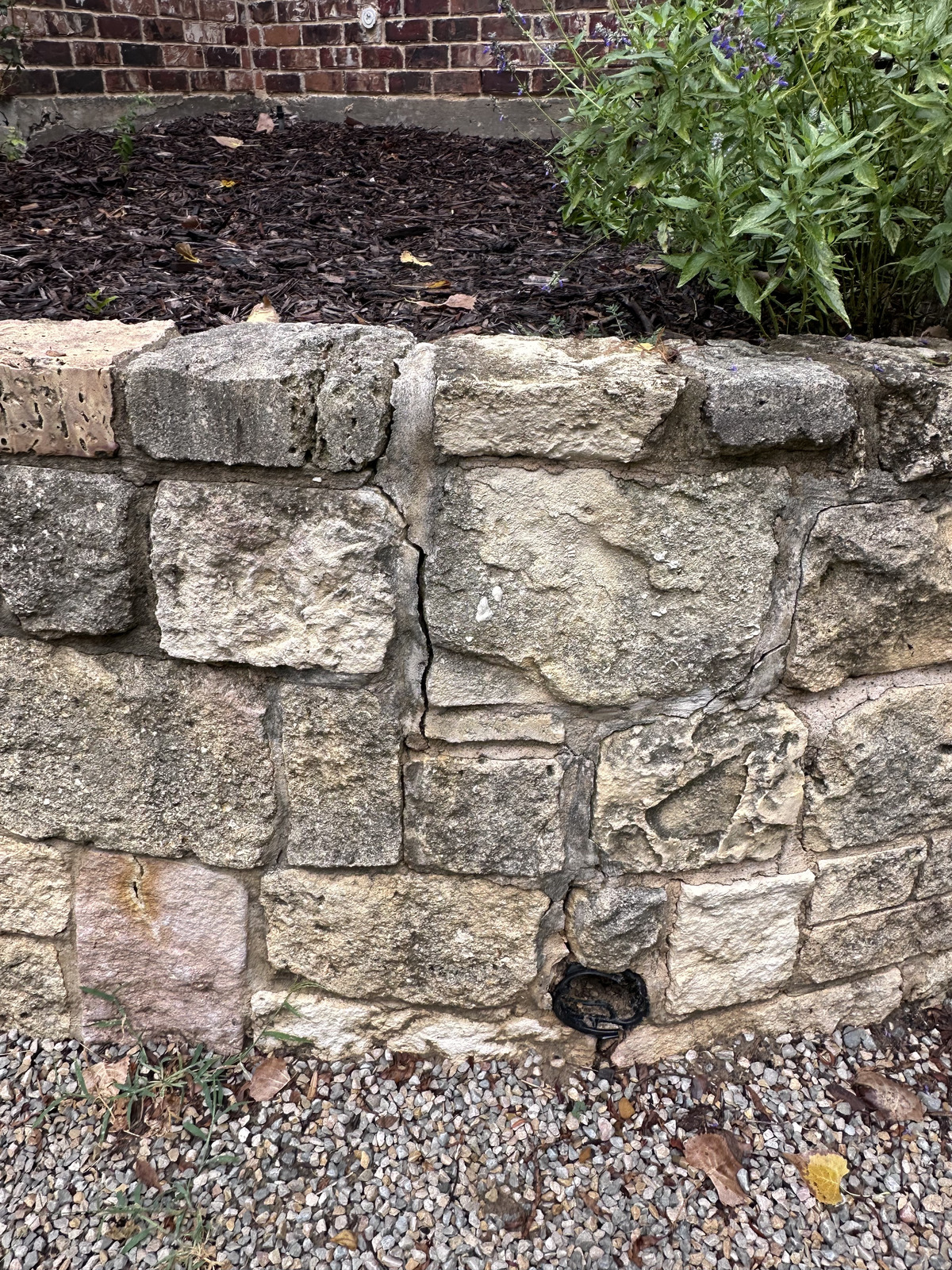 Cracked brick retaining wall in Fort Worth needing professional masonry repair — clay soil pressure and drainage failure